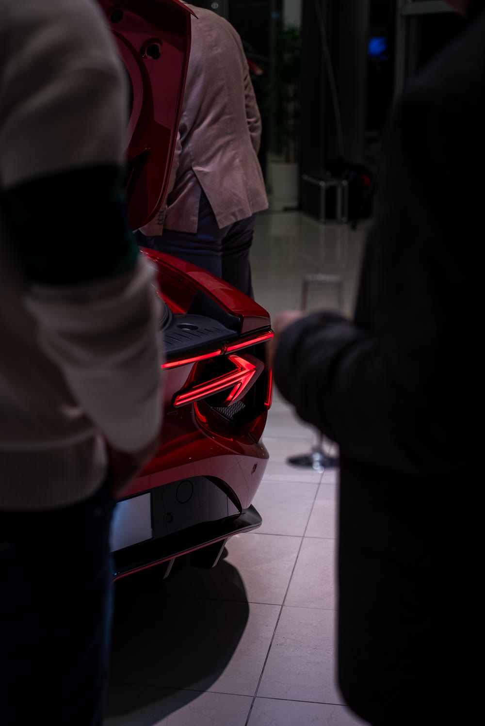 Detalj stražnjeg svjetla crvenog automobila između posjetitelja događaja